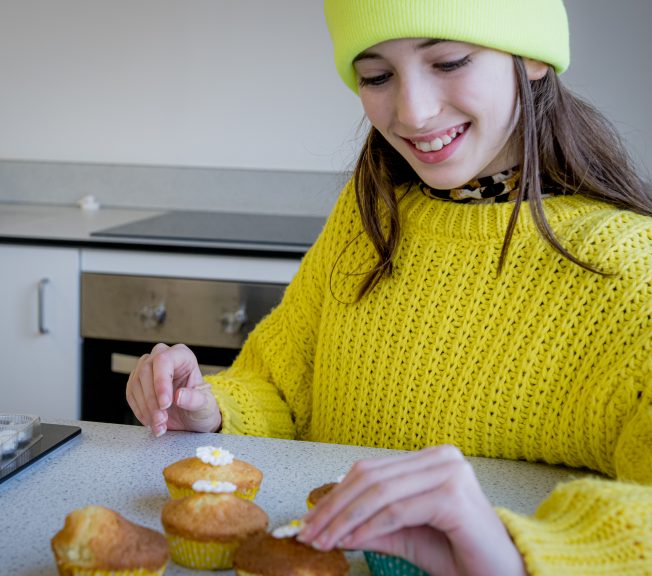 Student decorating cup cakes