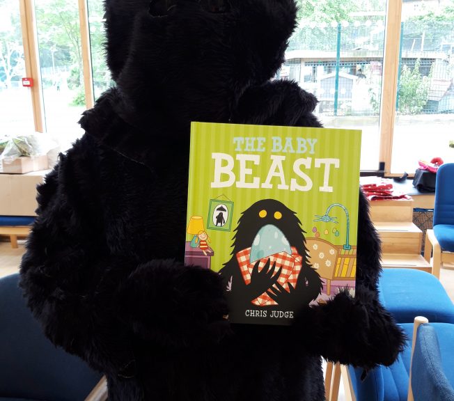 Person wearing a costume holding a picture book