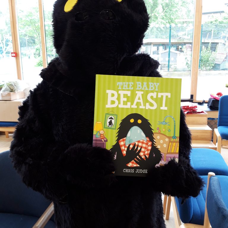 Person wearing a costume holding a picture book