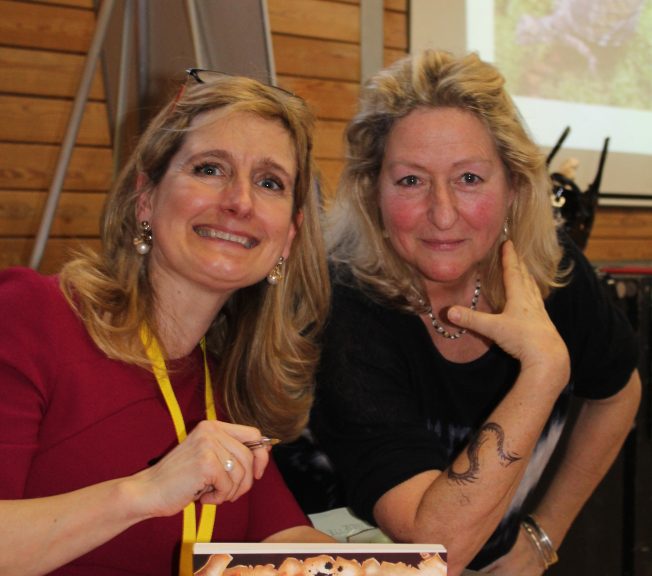 Two members of staff with a book