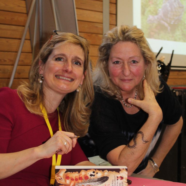 Two members of staff with a book