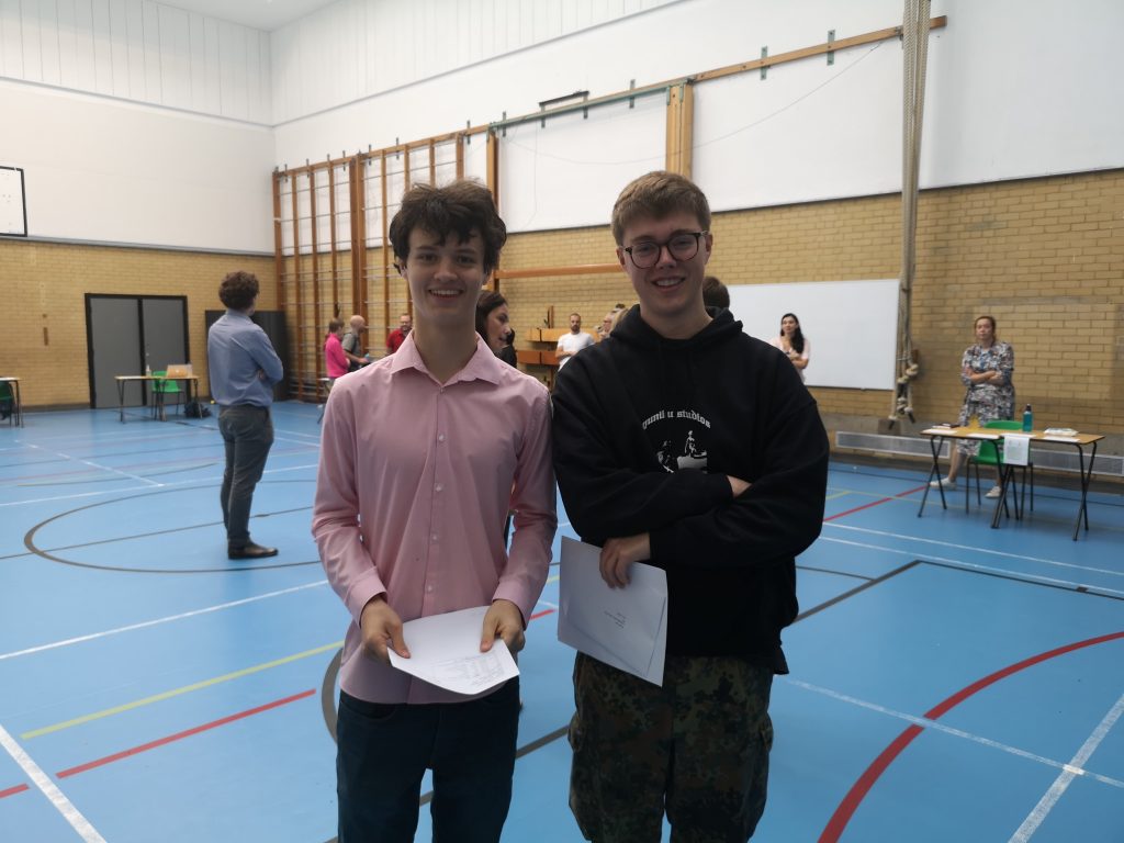 Two students holding exam results