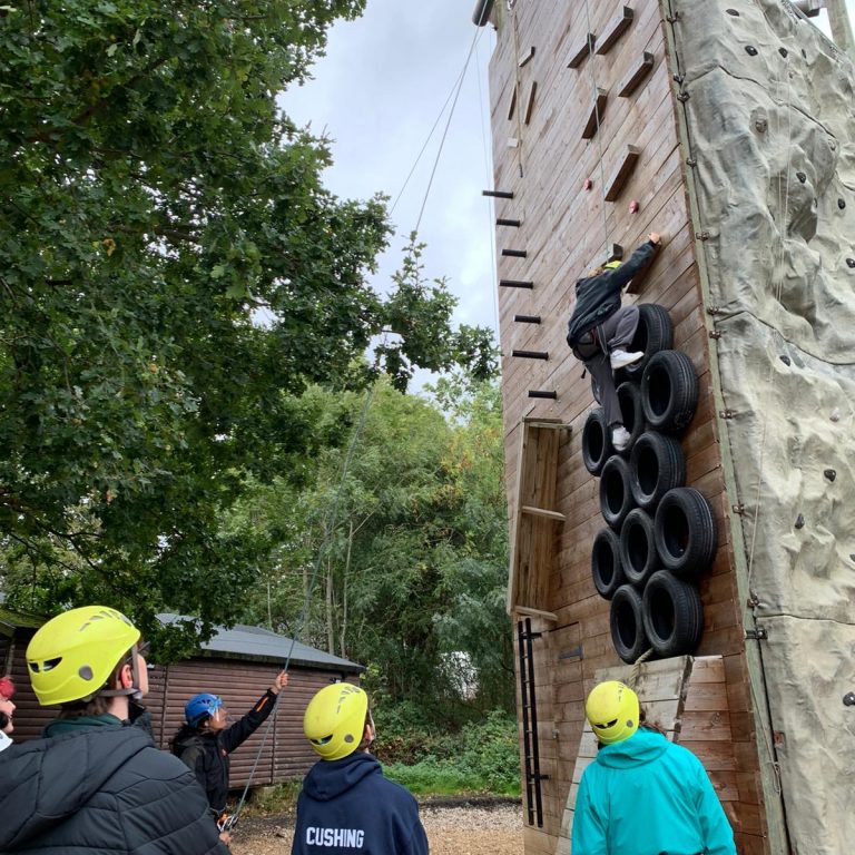 Student climbing on a wooden structure