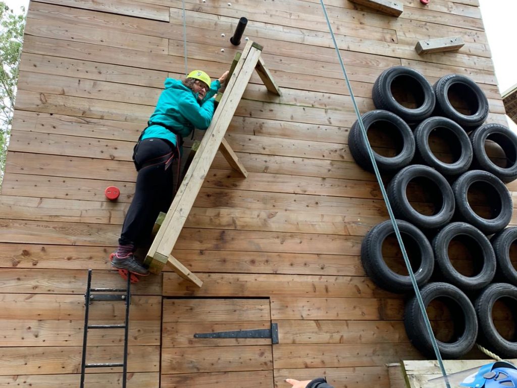 Student climbing on a wooden structure