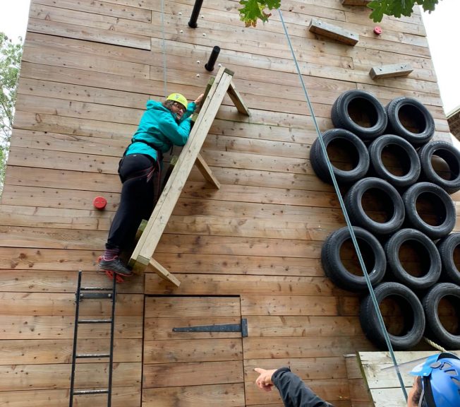 Student climbing on a wooden structure