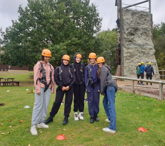 Group photo of students on autumn term camp wearing helmets for rock climbing