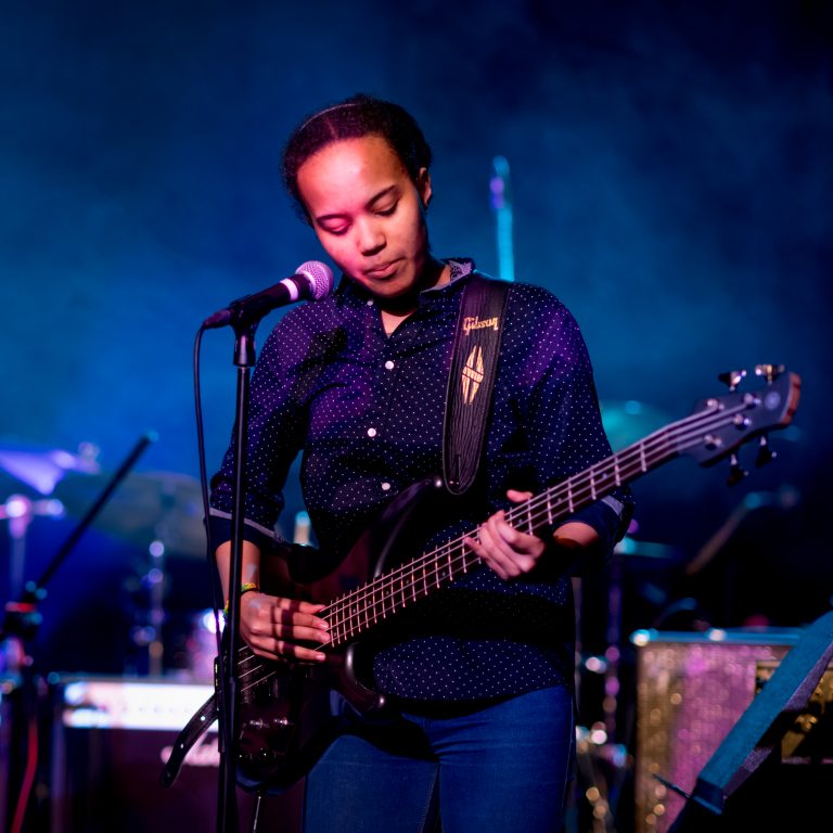 Student singing and playing guitar for school concert