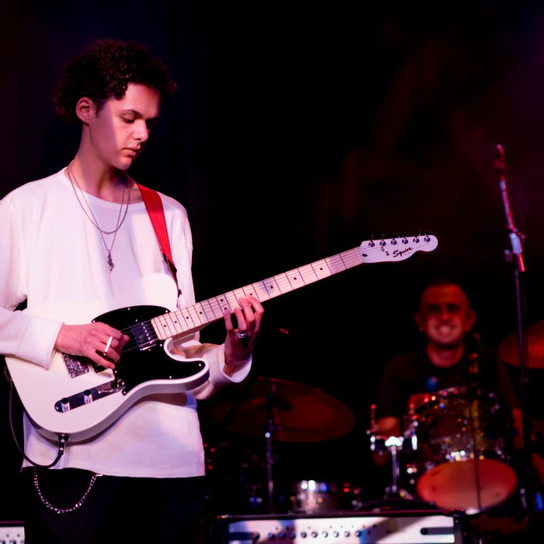 Student playing guitar for school concert
