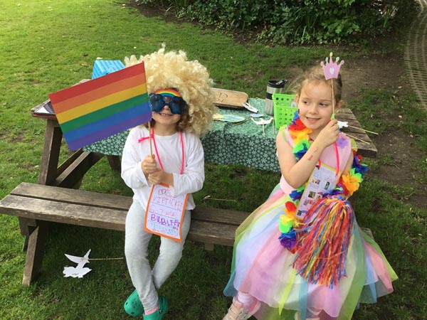 Students holding a rainbow flag and drawing of a crown