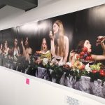 Students sitting at a long table with fruit and flowers