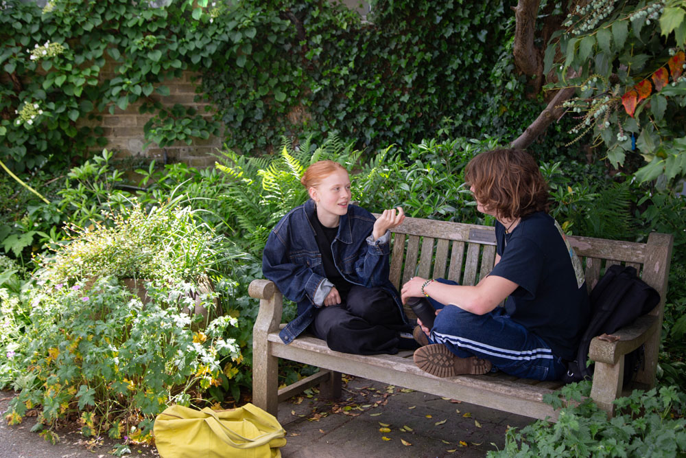 students talking on a bench