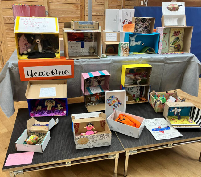 Two tables of decorated shoeboxes, with a sign that reads 'Year One'