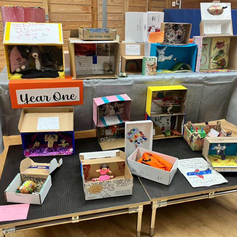 Two tables of decorated shoeboxes, with a sign that reads 'Year One'