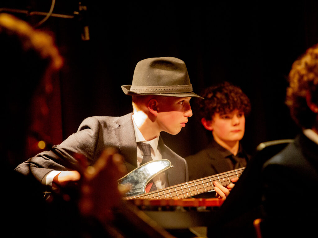 A student on stage playing the guitar at the jazz evening
