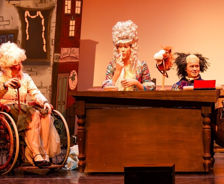Actors dressed as noblemen and women on stage