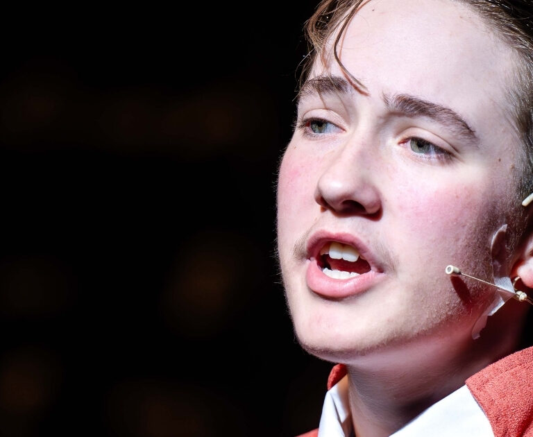 Close-up of an actor singing on stage