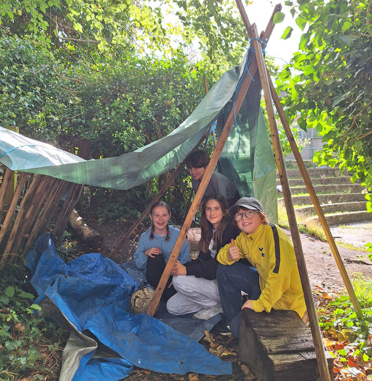 Students at The King Alfred School practice shelter building as part of a project on survival