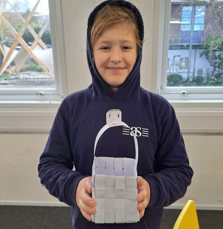 Student holding a handmade woven basket