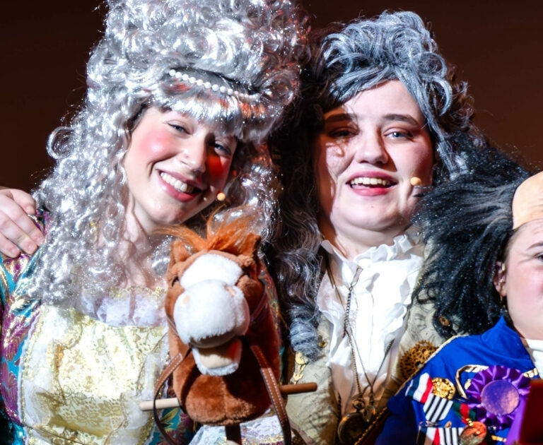 Close-up of three smiling actors in Regency outfits