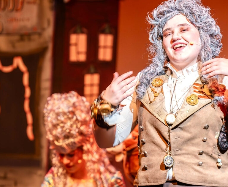 Happy female actor sings a song on stage