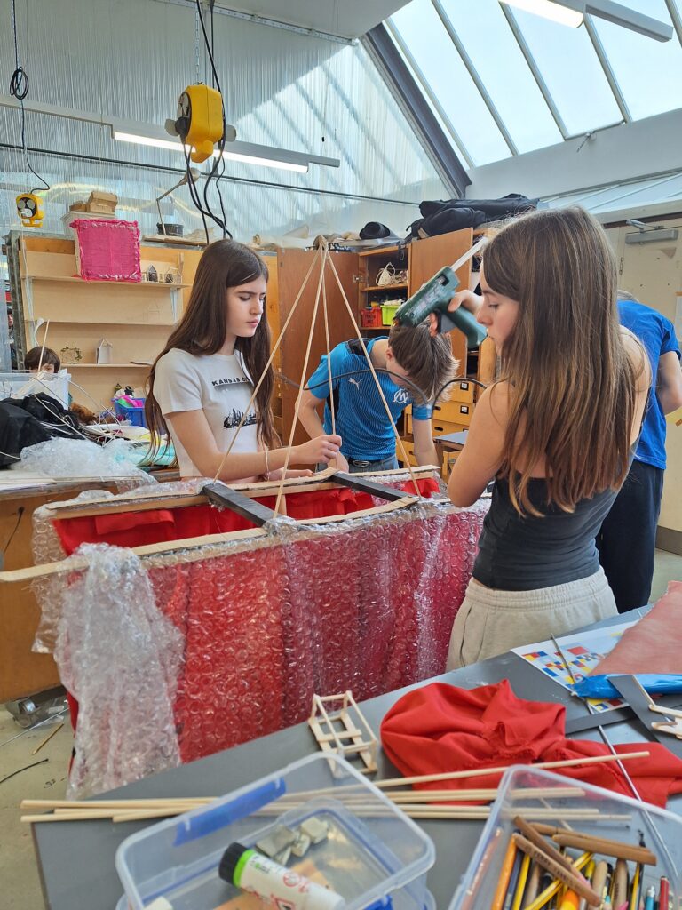 Students use a glue gun to crate a wooden structure in the art room at The King Alfred School