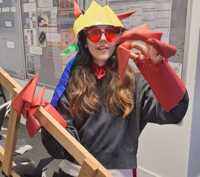 A female student wears 'claws' and cuffs made from red paper