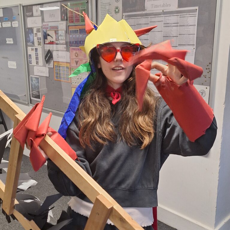 A female student wears 'claws' and cuffs made from red paper