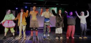 Students on stage at The King Alfred School North London take a bow after their clowning performance