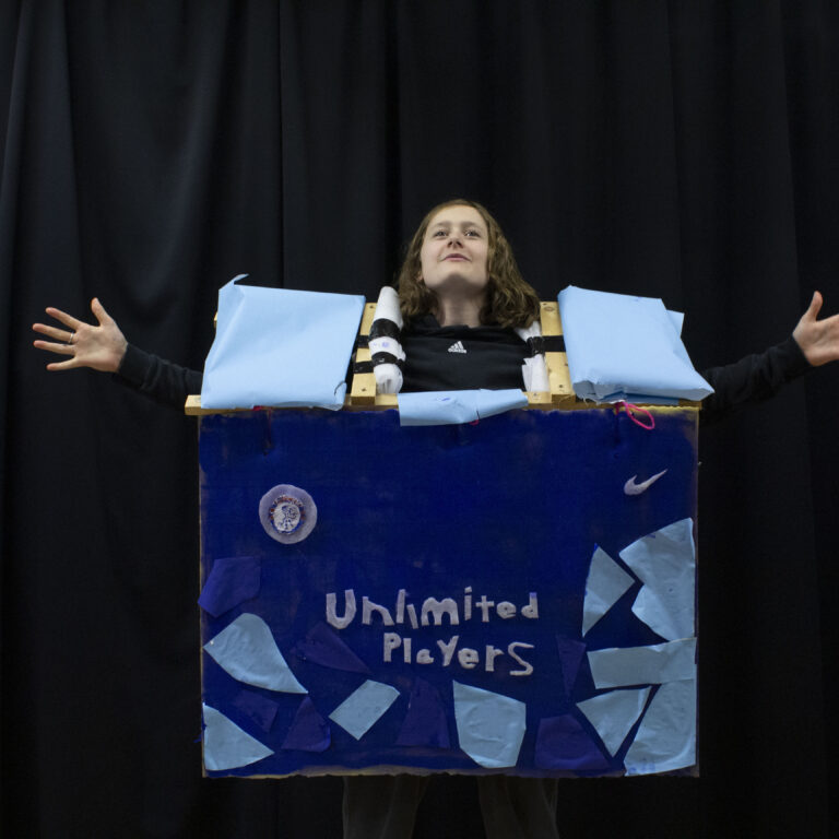 A student wears an abstract fashion design, featuring a blue box with the words 'Unlimited Players' on the front