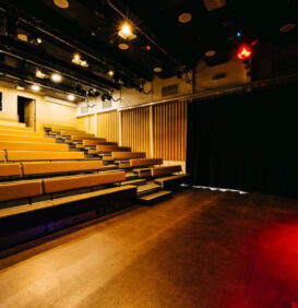 The King Alfred Phoenix Theatre with bench style seating in place and the stage lit up