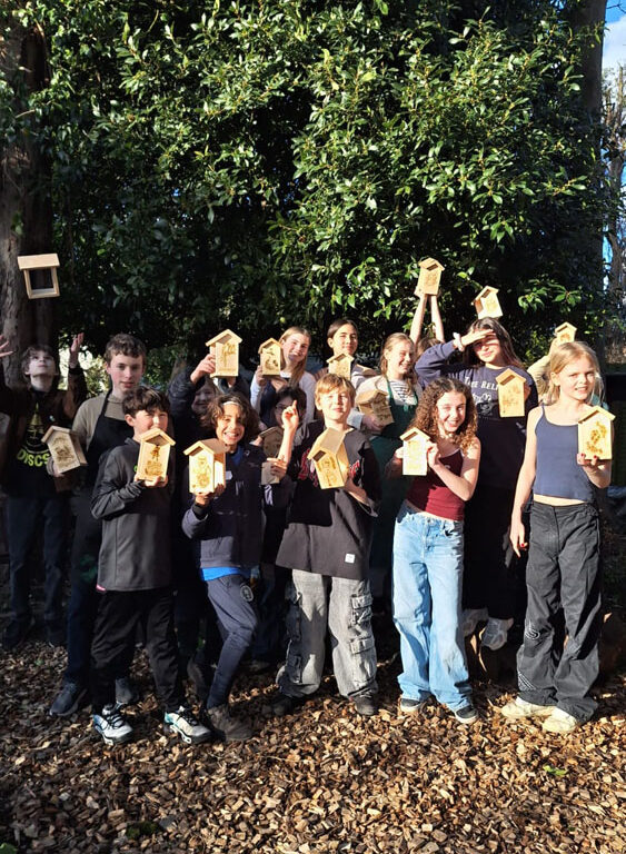 A group of students at The King Alfred School North London holding up bird feeders they have made in the Design Technology department