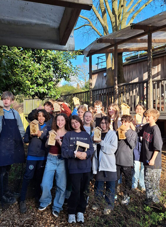 A group of students at The King Alfred School North London holding up bird feeders they have made in the Design Technology department