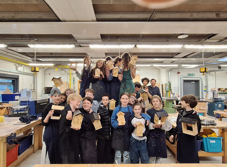 A group of students at The King Alfred School North London holding up bird feeders they have made in the Design Technology department