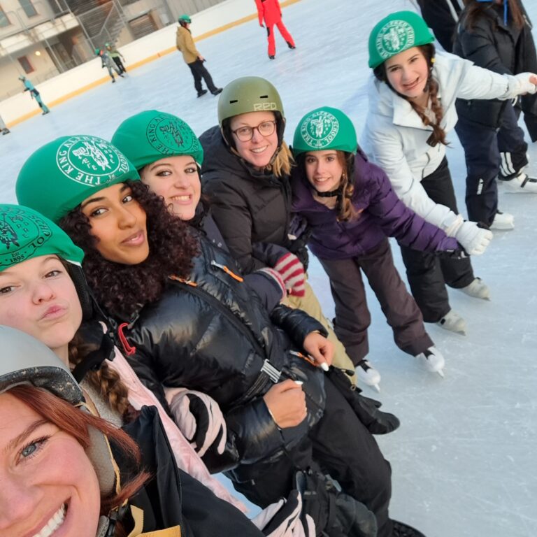 Students and teachers from The King Alfred School pose in a line on an outdoor ice rink