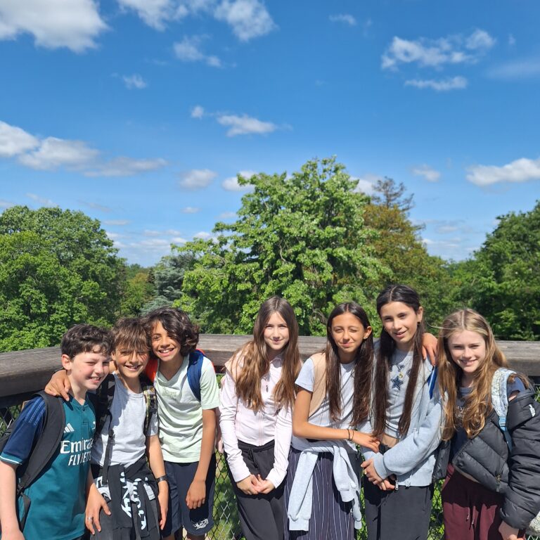 A group of students smile on a treetop walkway at Kew Gardens