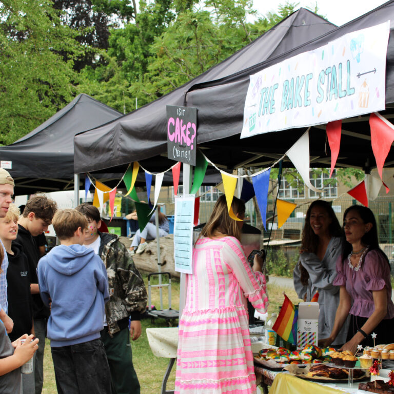 People queue for a cake stall at a school fair