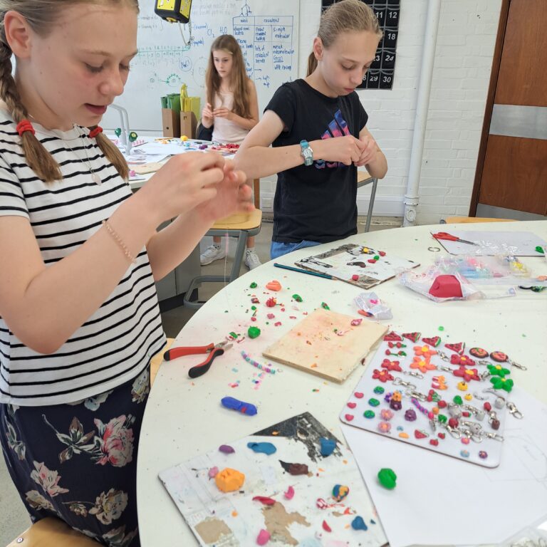 Students use beads and clay to make phone charms and items of jewellery