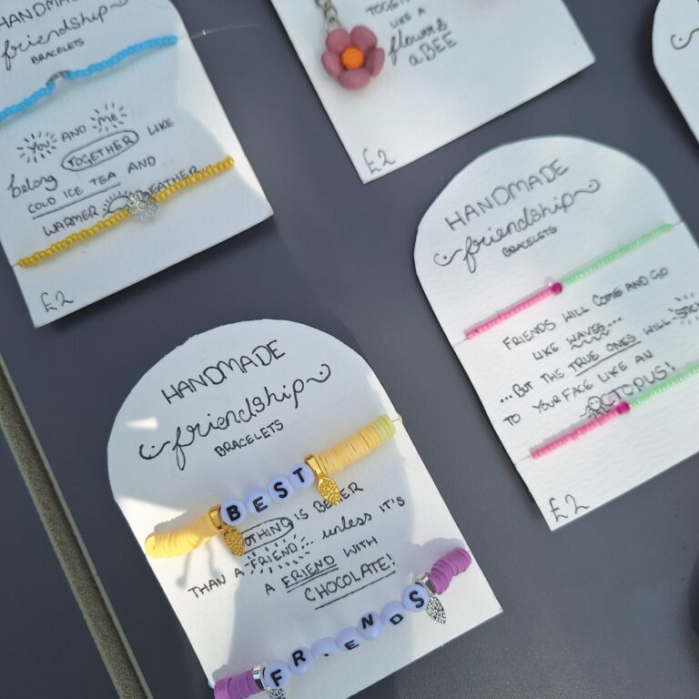 Student-made friendship bracelets mounted onto cards featuring heartwarming self-penned captions, such as "you and me belong together like cold iced tea and warmer weather"