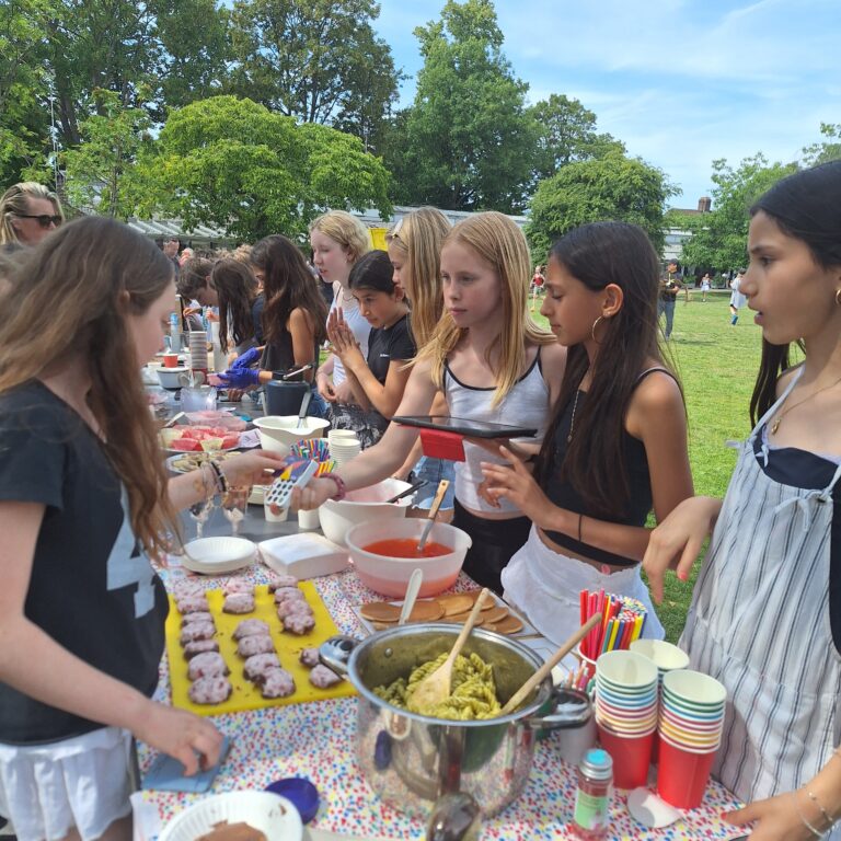 A student makes a contactless payment at a stall selling cakes and pasta
