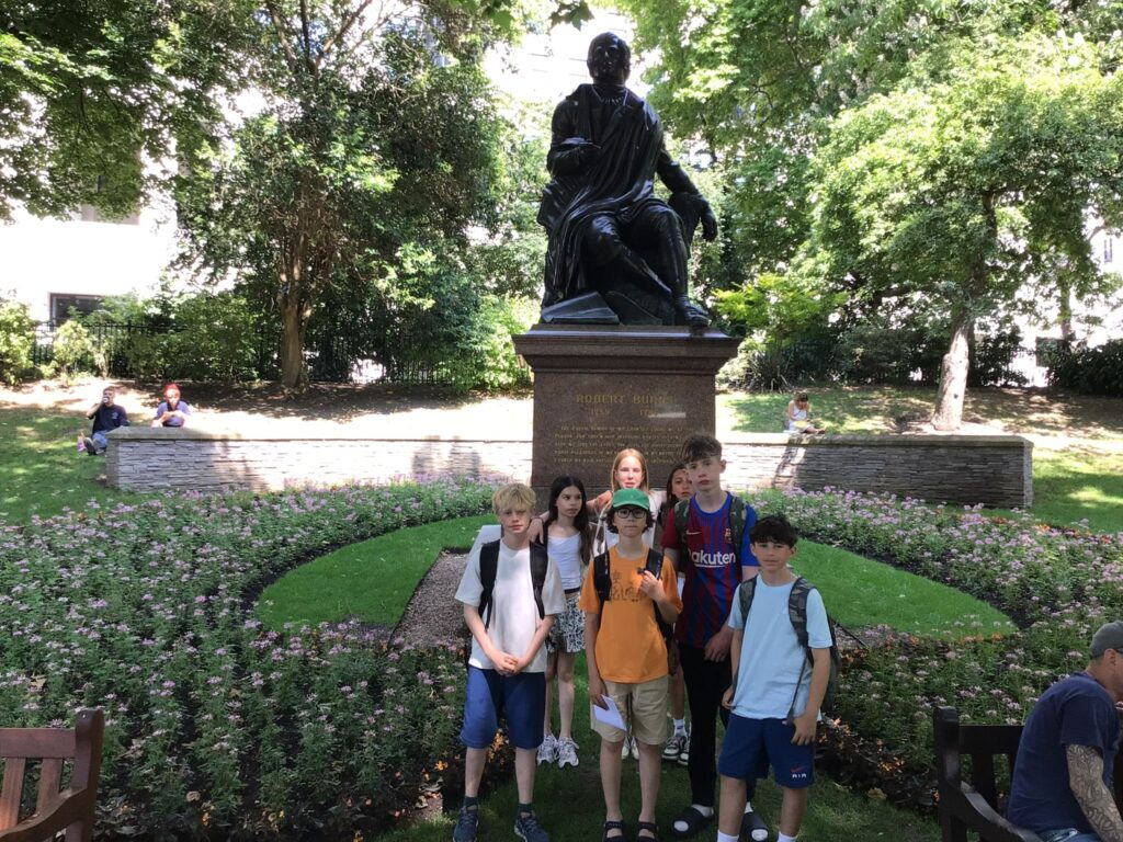 Year 7 students from The King Alfred School in North London standing in front of a statue of Robert Burns in Central London