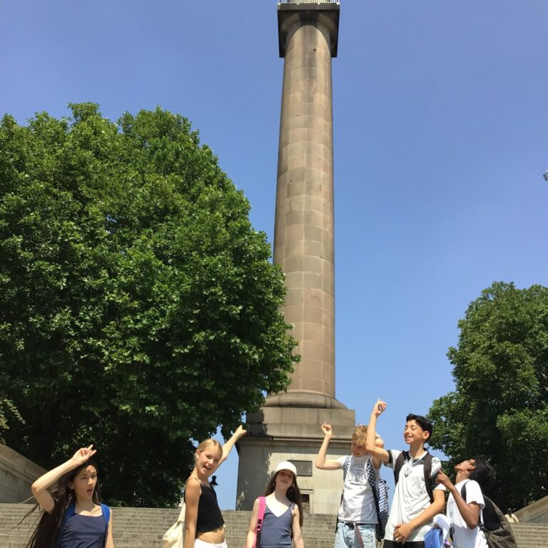 Year 7 students from The King Alfred School pointing at Nelson's Column in Trafalgar Square, London