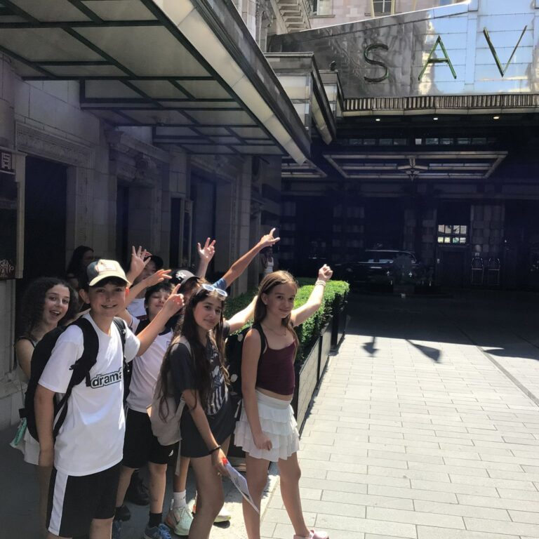 Year 7 students from The King Alfred School pointing at the entrance to The Savoy Hotel in Central London