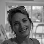 Black and white headshot of a woman with sunglasses on her head