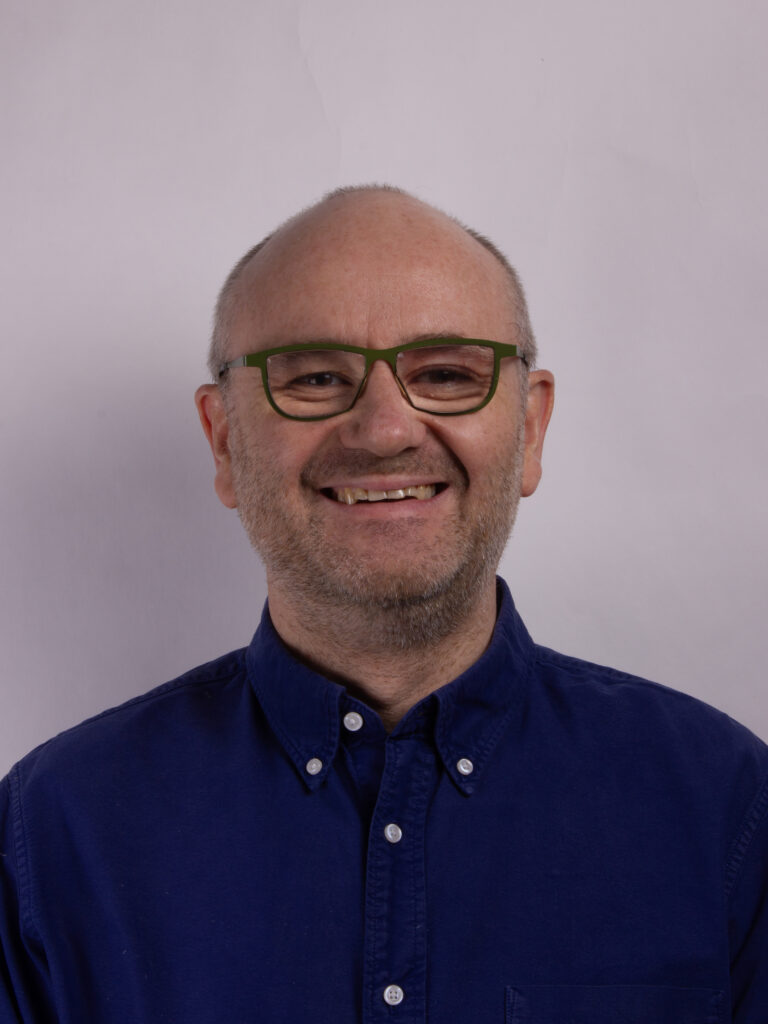 Headshot of a man wearing glasses and wearing a navy blue shirt