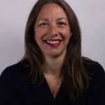 Headshot of a woman with long brown hair wearing a black shirt