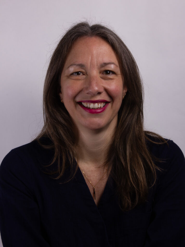 Headshot of a woman with long brown hair wearing a black shirt