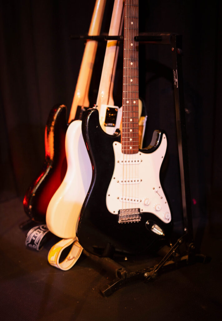 three guitars stacked up beside a stage